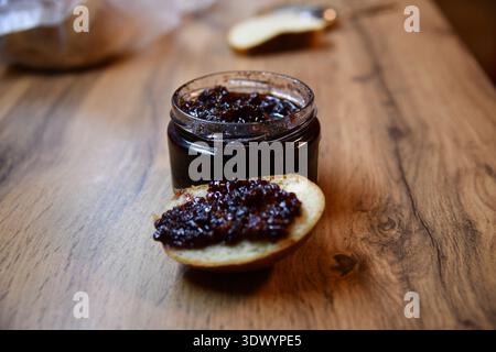 Sandwiches mit Pflaume, Erdbeermarmelade und frischem Obst auf hölzernem Hintergrund Stockfoto