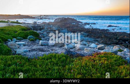 Blick auf den Sonnenuntergang auf die felsige Küste und den Ozean Horizont vom Beach Point Vista Point in Monterey, Kalifornien Stockfoto