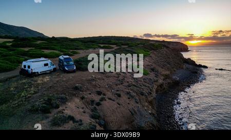 Hochwinkelansicht von zwei Wohnmobilen auf einer wilden Landzunge auf Capo Sperone, Insel Sant'Antioco, Sardinien, Italien. Das Bild erfasst den spiri Stockfoto