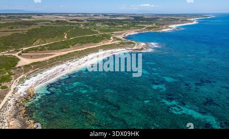 Atemberaubender Blick von oben auf den berühmten Strand Arutas auf der Sinis-Halbinsel. Das Foto erfasst den lebendigen Kontrast zwischen dem kristallklaren Bild Stockfoto
