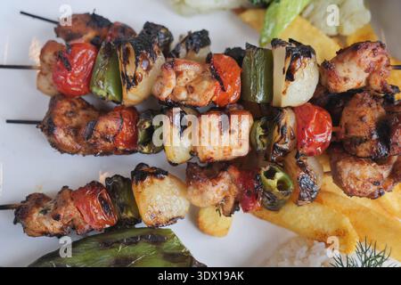 Gegrillte Fleisch- und Gemüsespieße mit Beilagen Stockfoto