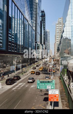 New York City, USA – 14. Februar 2026: Straßenverkehr und Stadtstraßen entlang der 10th Avenue vom Hochgelegenen High Line Park aus gesehen. Stockfoto