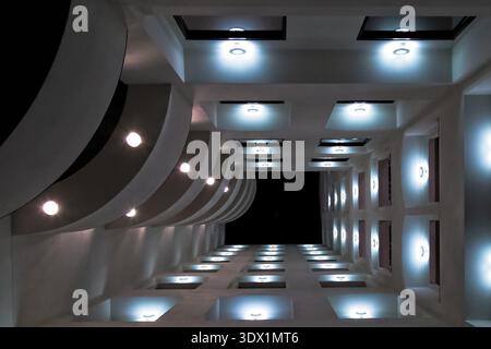 Eine Niedrigwinkelaufnahme des Außenbereichs eines modernen Gebäudes bei Nacht, beleuchtet von zahlreichen Lichtern. Stockfoto