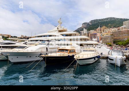 Relativ kleine Boote vor einer luxuriösen Superyacht, die in Port Hercule, La Condamine, Monaco, vor Anker liegt Stockfoto