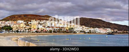 Panoramablick auf die sandige Küste, das ruhige Meer und die Resorts von Playa de las Vistas in Playa de las Americas vor einer bergigen Kulisse auf Teneriffa. Stockfoto