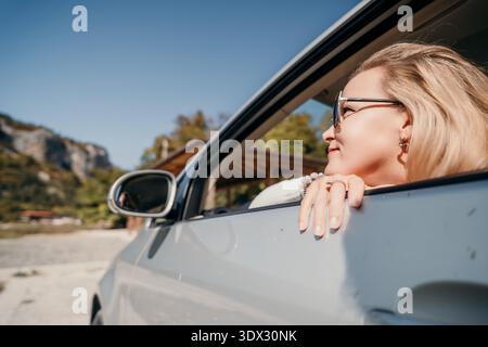 Frau im Auto, die aus dem Fenster sieht Stockfoto