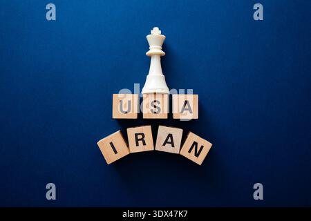 Schachkönigsteil, der auf den Blöcken der usa und des iran steht und geopolitische Konflikte und Strategien repräsentiert Stockfoto