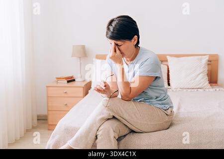 Reife Frau hat Kopfschmerzen, Augenschmerzen zu Hause Stockfoto