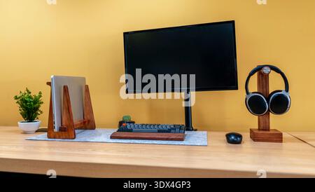 Modernes Home Office-Design mit Kopfhörern für Laptop-Monitore und minimalem Arbeitsplatzdesign für Produktivität Stockfoto