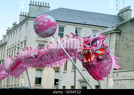 Glasgow, Schottland, Großbritannien. März 2026. Wetter in Großbritannien: Bei der nassen chinesischen Neujahrsdrachenprozession zogen sie um die sauchiehall Street, bevor sie mit dem Pfeifenband für eine Decke hielten. . Credit Gerard Ferry/Alamy Live News Stockfoto