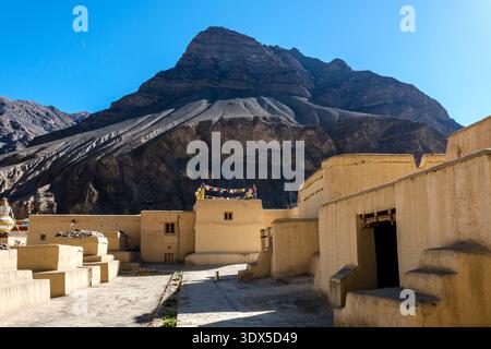 Im Vordergrund stehen traditionelle Lehmziegelbauten des Klosters Tabo, in der Ferne steigen die zerklüfteten Gipfel des Spiti-Tals. Stockfoto