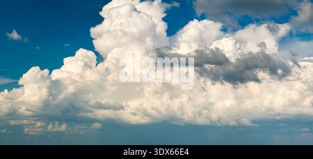 Helle Landschaft des blauen Himmels mit fliegenden weißen Wolken. Farbenfrohe Sommerhimmel Stockfoto