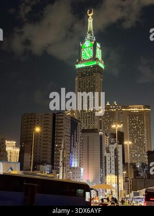 Nachtblick auf den Abraj Al Bait Uhrenturm in Mekka mit beleuchteter grüner Uhr und Skyline der Stadt Stockfoto