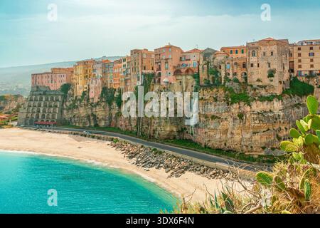 Historische Gebäude der Altstadt von Tropea auf einer Klippe über dem türkisfarbenen Meer und dem Sandstrand Rotonda, Kalabrien, Italien. Italienische Architektur auf dem Felsen Stockfoto
