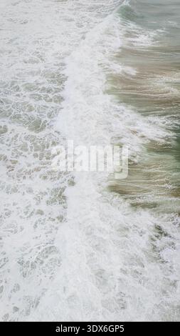 Ein atemberaubender Blick auf die Drohne fängt die dynamischen Wellen ein, die an den Ufern des Atlantic Beach in Portugal krachen, und zeigt die natürliche Schönheit und die riesige Aussicht Stockfoto