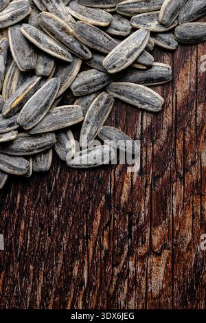 Nahaufnahme gesalzener Sonnenblumenkerne auf einer rustikalen Holzoberfläche, die ihre Textur und ihr natürliches Aussehen unterstreicht. Ideal für Themen der Heilung Stockfoto