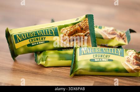 Mehrere einzeln verpackte Nature Valley Crunchy Oats & Honey Müsliriegel auf einer Holzoberfläche. Stockfoto