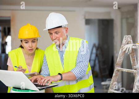 Architektin und Ingenieur mit Laptop auf der Baustelle Stockfoto