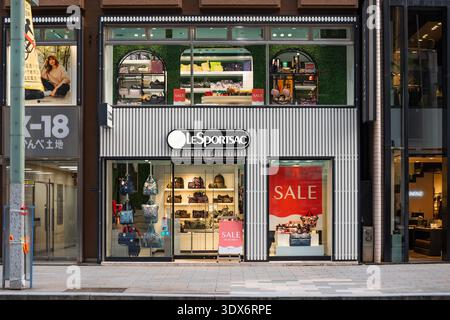 Tokio, Ginza - 08. Januar 2025: Die moderne japanische Ladenfront von LeSportsac zeigt farbenfrohe Nylontaschen und knallrote Verkaufsschilder hinter dem Glasfenster Stockfoto