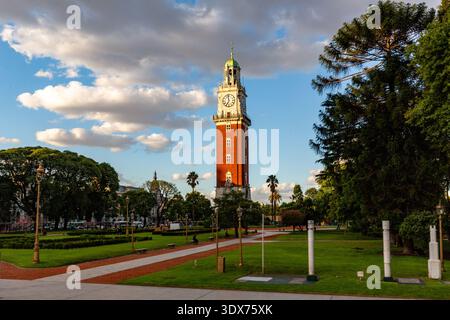 Der berühmte Uhrenturm der Universität von Buenos Aires, auch bekannt als „Torre de los Ingleses“ (englischer Turm), steht hoch vor dem Hintergrund eines teilweise bewölkten Himmels. Der Turm, ein prominentes Wahrzeichen der Stadt, ist umgeben von üppig grünen Rasenflächen, gepflegten Hecken und Reifen Bäumen, die eine ruhige, parkähnliche Atmosphäre schaffen. Man kann beobachten, wie man durch den Park schlendert und auf Bänken sitzt und das angenehme Wetter und die architektonische Schönheit des Turms genießt. Die Szene fängt einen Moment der Ruhe und der urbanen Schönheit ein und unterstreicht die historische Bedeutung des Turms und seine Integration Stockfoto