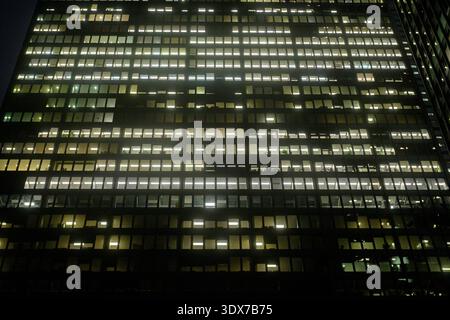 Toronto, ON, Kanada - 10. Dezember 2025: Ein Bürogebäude zeigt viele beleuchtete Fenster während der Nacht und symbolisiert das städtische Leben. Stockfoto