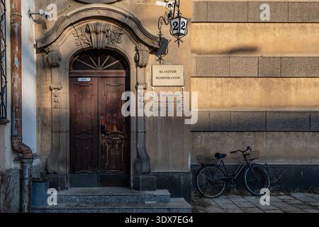 Eingang zum historischen Gebäude mit einem Fahrrad, das bei Sonnenuntergang in der Nähe parkt Stockfoto