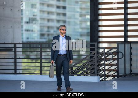 Erfolgreicher Geschäftsmann aus den 40er Jahren in Anzug mit Aktentasche in voller Länge. Geschäftsmann im Anzug. Reifer, stylischer Banker im Anzug. Hispanischer Unternehmer. Unternehmen Stockfoto