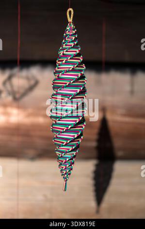 Kunsthandwerk mit natürlichem Stroh .Strohspirale Hintergrund. Draufsicht. Goldene Spirale. Eine Spirale, ein Drehteller, gewebt aus buntem Stroh. Stockfoto