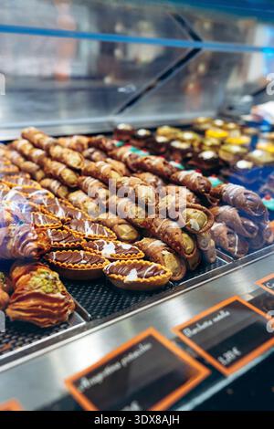 In einer Bäckerei werden in einem geschäftigen Geschäft verschiedene Desserts gezeigt Stockfoto