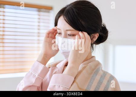 Eine junge Frau mit Maske fühlt sich unwohl Stockfoto