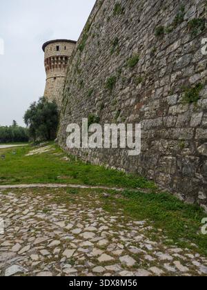 Massive Steinmauer Der Festung, Die Zur Ecke Des Runden Turms Führt, Brescia, Italien. Stockfoto