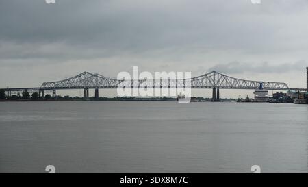 Die Crescent City Connection Bridge überspannt den Mississippi River in New Orleans, Louisiana, USA, unter bewölktem Himmel. Stockfoto