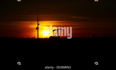 Pumpjack als Silhoutte bei Sonnenuntergang in den Ebenen von Texas Stockfoto