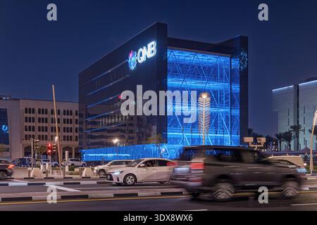 29. November 2025, Doha, Katar: Hauptsitz der katarischen Nationalbank bei Nacht, moderne Architektur und Stadtentwicklung mit Stadtverkehr Stockfoto