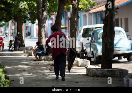 Eine Frau, die die Straße in Ciego de Avila, Kuba, entlang läuft Stockfoto