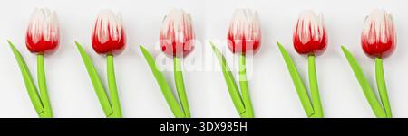 Ornament aus künstlichen Blumen, Holz- rote Tulpen auf einem weißen Hintergrund. Blumen muster Ornament. Schönen weiß-rote Tulpen Holz mit Grün verlassen Stockfoto