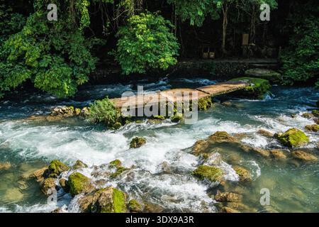 Klares türkisfarbenes Wasser, das über eine natürliche Kalksteinbarriere in Xiaoqikong Scenic Area, Libo County, Provinz Guizhou, China fließt. Stockfoto