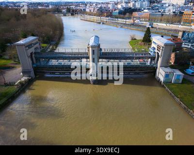 Aus der Vogelperspektive auf den Fluss, der durch den Damm fließt, mit seinem grauen Beton im Kontrast zum schlammigen Wasser, Saint-Ouen-sur-seine, Île-de-France, Fran Stockfoto