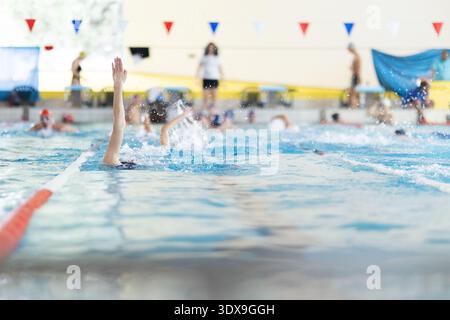 Schwimmer trainieren im Hallenbad mit Trainer Stockfoto