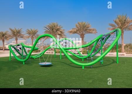 6. Dezember 2025, Abu Dhabi, Vereinigte Arabische Emirate: Grüne Outdoor-Spielplatzgeräte, die Spaß, Erholung und körperliche Aktivität in einem sauberen Stadtpark bieten Stockfoto