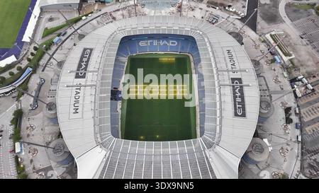Blick aus der Vogelperspektive auf das Etihad Stadion, das in sanftem Licht getaucht ist, dessen lebhaftes Grün im Kontrast zu den silbernen Tribünen steht, ein modernes kolosseum des Sports, Manch Stockfoto
