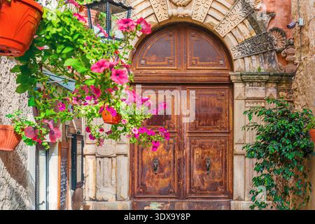 Positano historische Tür mit Blumen und traditioneller italienischer Architektur in der Altstadt von Kampanien, Italien. Mediterranes Gebäude mit Holztür Stockfoto