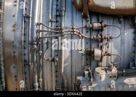 Die Szene zeigt eine Nahaufnahme von Metallrohren und Ventilen, die mit Maschinen verbunden sind. Die Einstellung scheint ein Industriestandort mit sichtbaren Komponenten zu sein. Die Stockfoto