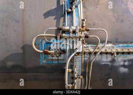 Die Metalloberfläche besteht aus Rohren und Ventilen, die miteinander verbunden sind. Der Schwerpunkt liegt auf dem industriellen Aufbau, der technische Elemente zeigt. Das ist wahrscheinlich fou Stockfoto
