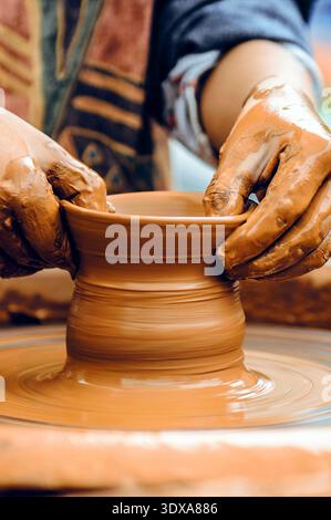 Nahaufnahme eines Töpfers Hände bei der Arbeit. Potter-Hände Formen Ton auf einem Keramikrad Stockfoto