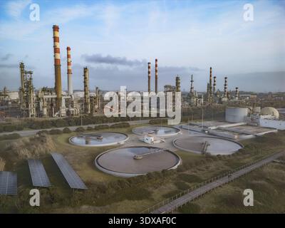 Luftaufnahme des Industriekomplexes mit zylindrischen Strukturen und Kaminen, die zum Himmel reichen, im Kontrast zur natürlichen Landschaft Matosinho Stockfoto