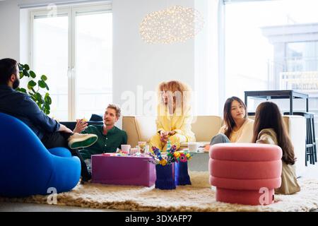 Gruppe von Geschäftsexperten, die sich im Büro in der Lobby unterhalten Stockfoto