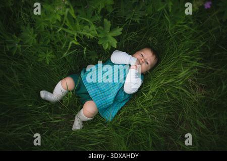 Direkt über dem Schuss des süßen Jungen, der auf dem Feld auf Gras liegt Stockfoto