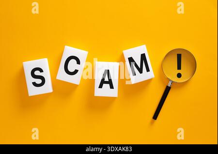 Betrügerische Wortkacheln mit einer Lupe, die ein Ausrufezeichen anzeigt, was auf Vorsicht, Betrugswarnung und Untersuchung hinweist Stockfoto