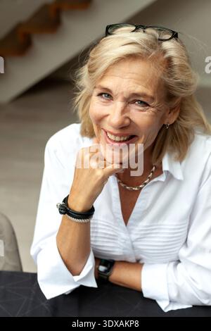Porträt einer glücklichen Seniorin, die mit Hand am Kinn posiert Stockfoto